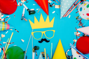 top view of face with crown made of holiday decor on blue surface